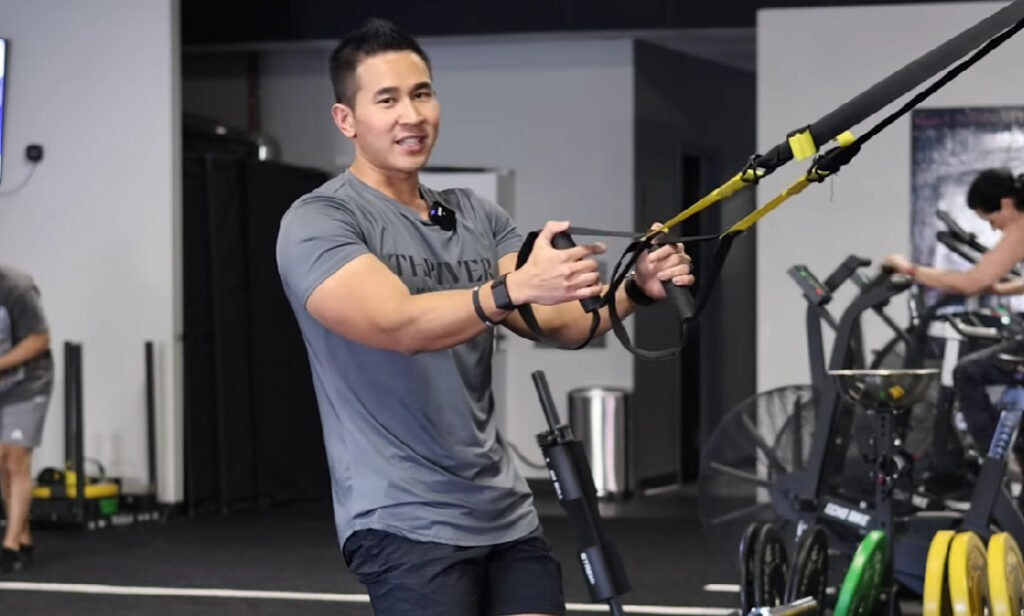 Demonstrate assisted pistol squat with TRX